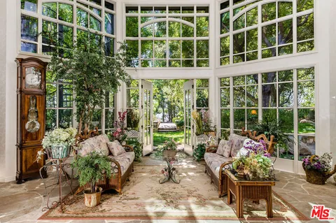 a living room filled with furniture and potted plants