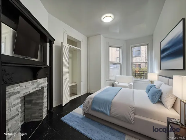 a bedroom with a bed a flat tv screen and a window