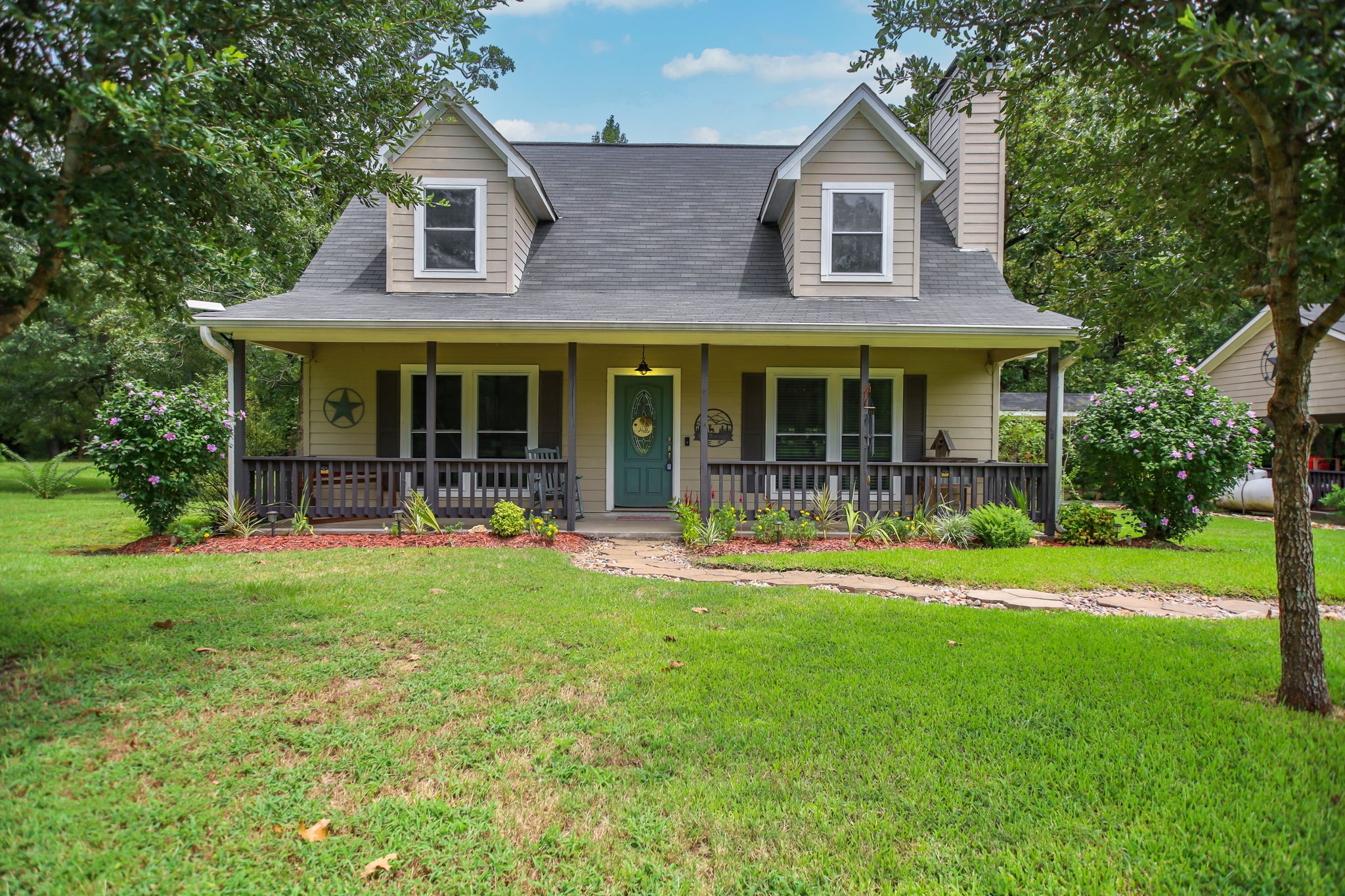 a front view of a house with a garden and porch