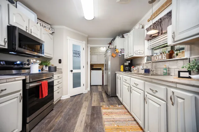 a kitchen with stainless steel appliances granite countertop a stove a sink and a refrigerator