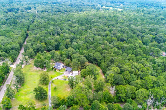 a view of a green field with an trees in the background