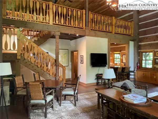 a living room with furniture kitchen view and a large window