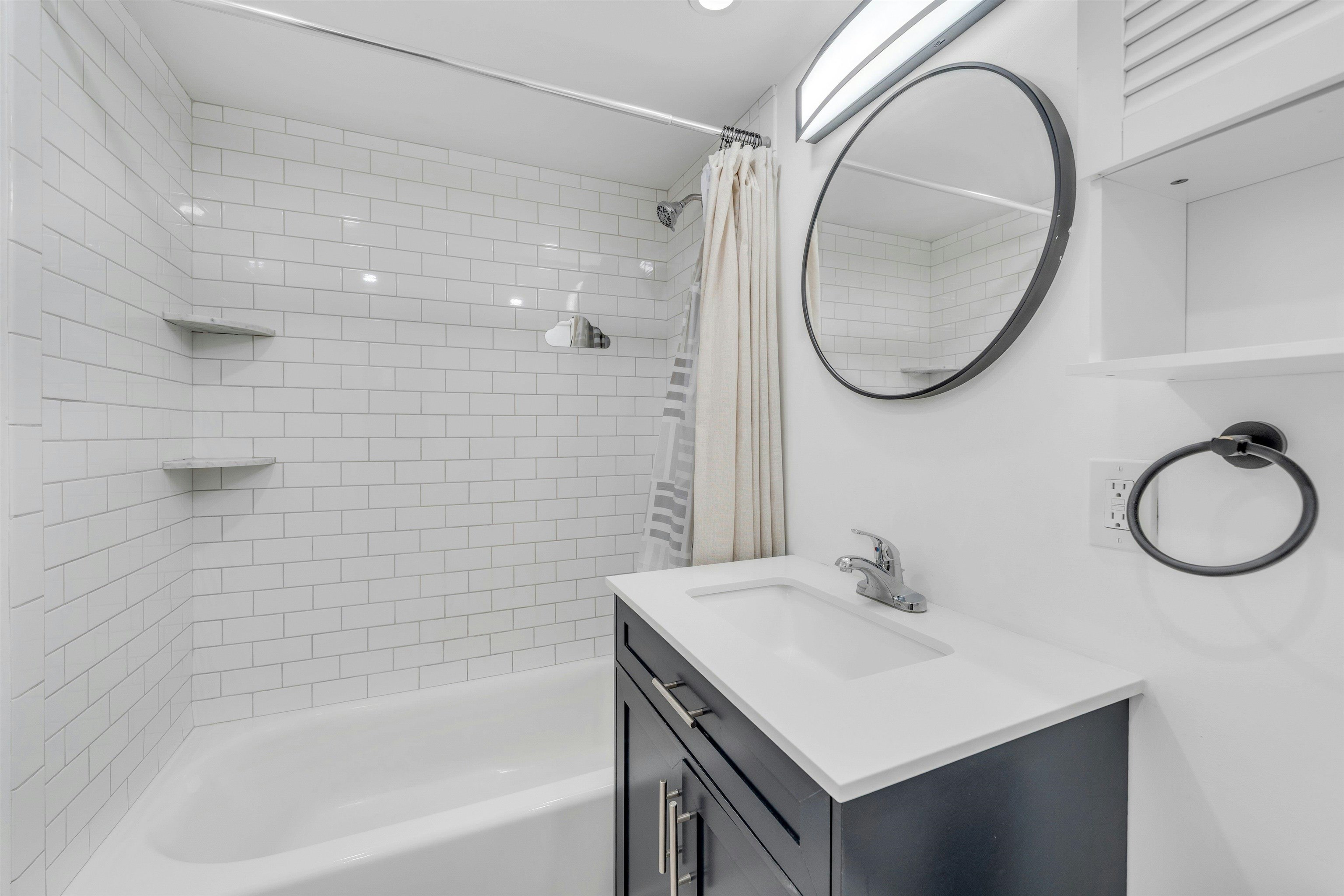 722 27th Street, Unit G Union City, NJ 07087 - Photo 13 of 25 a bathroom with a sink a bathtub and a mirror