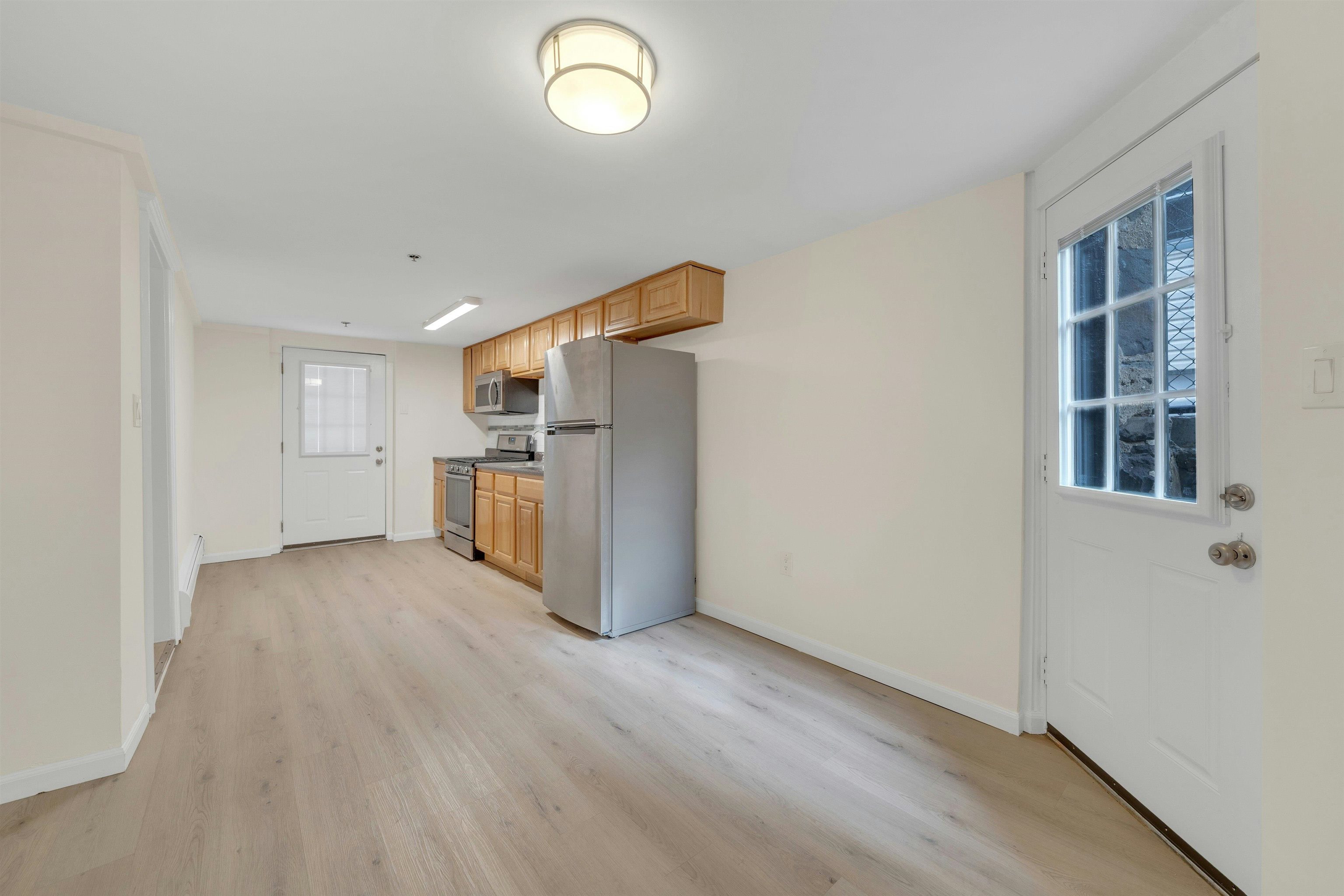 722 27th Street, Unit G Union City, NJ 07087 - Photo 3 of 25 wooden floor in an empty room with a kitchen