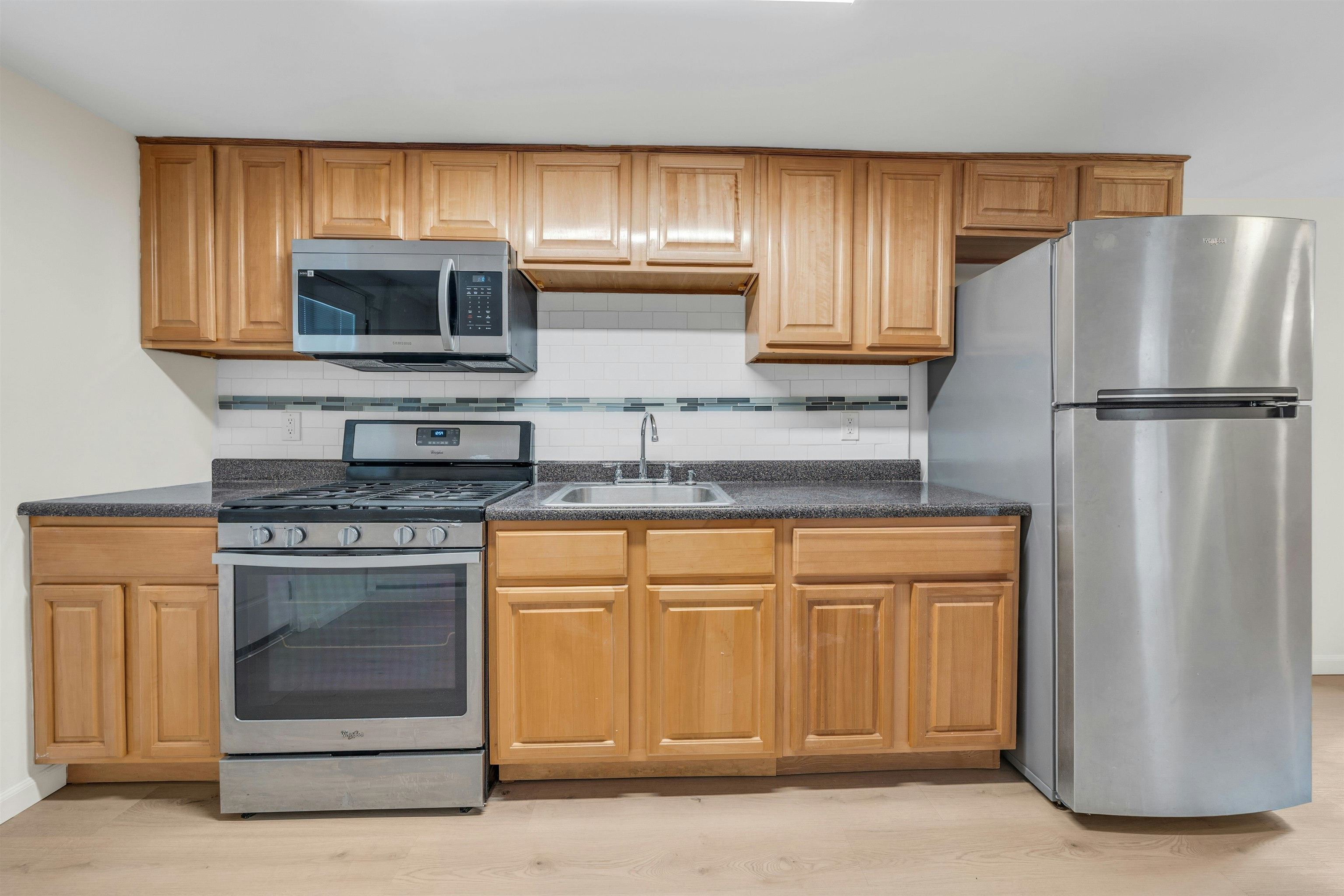 722 27th Street, Unit G Union City, NJ 07087 - Photo 4 of 25 a kitchen with stainless steel appliances granite countertop a refrigerator and a stove