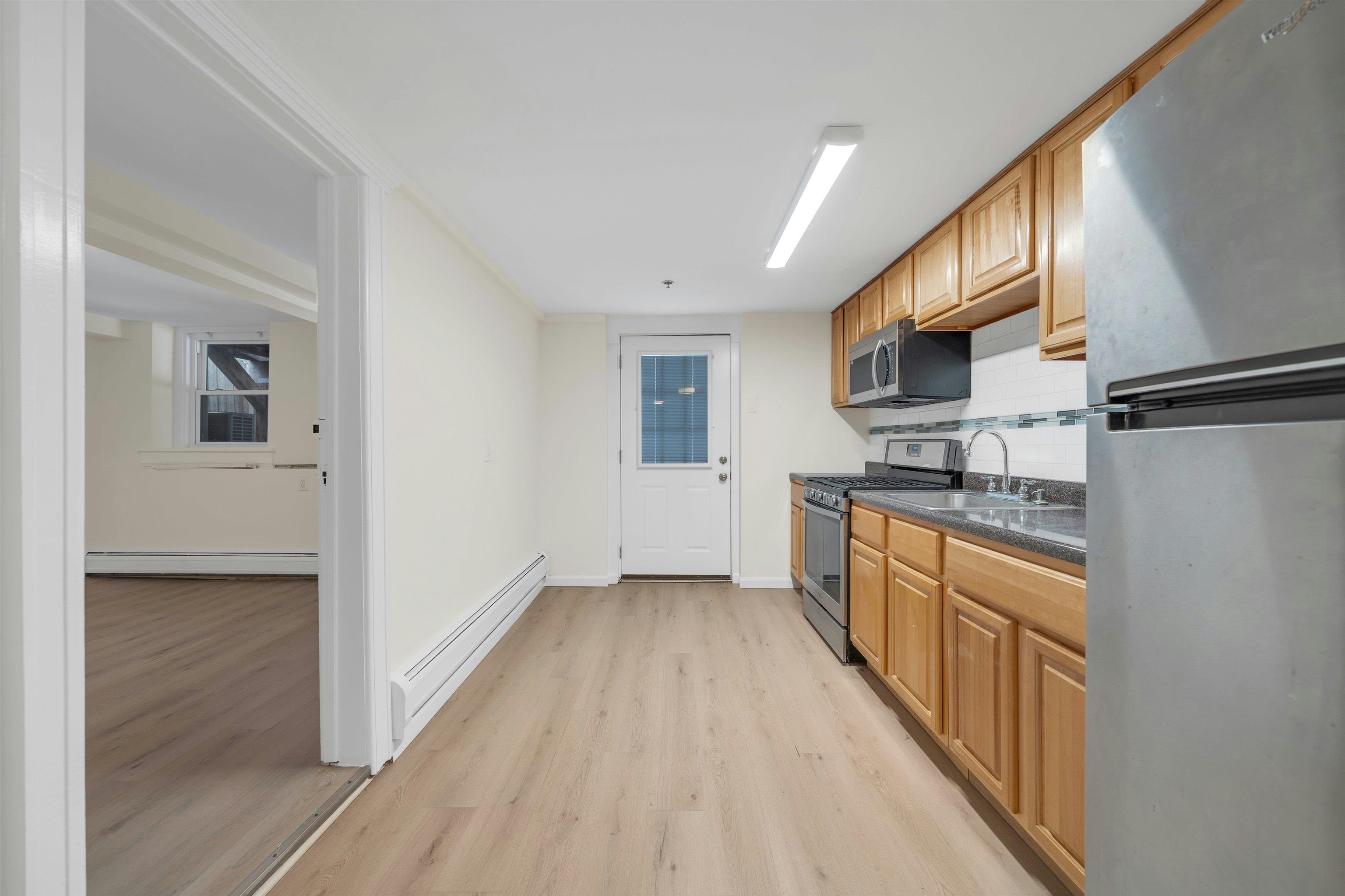 722 27th Street, Unit G Union City, NJ 07087 - Photo 6 of 25 a kitchen with stainless steel appliances granite countertop a refrigerator a stove top oven a sink dishwasher and wooden floor