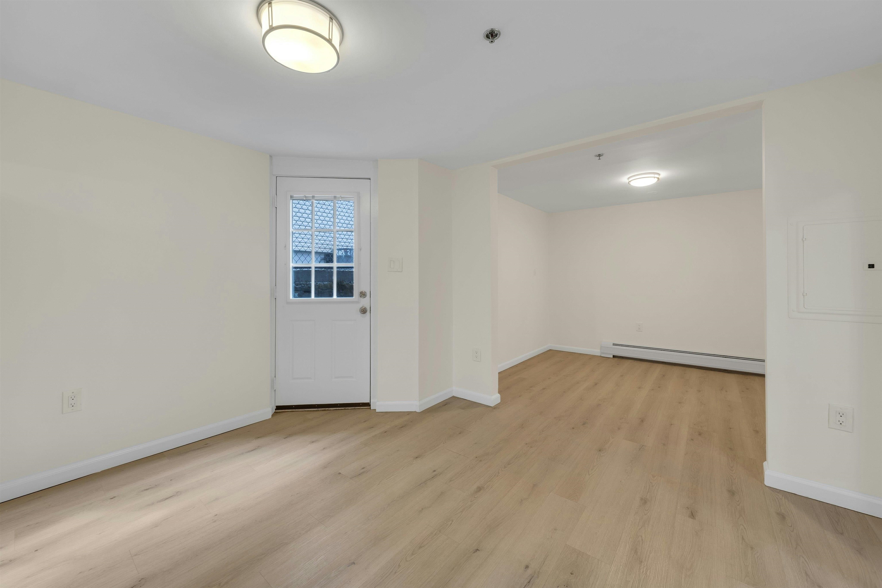 722 27th Street, Unit G Union City, NJ 07087 - Photo 8 of 25 an empty room with wooden floor and windows
