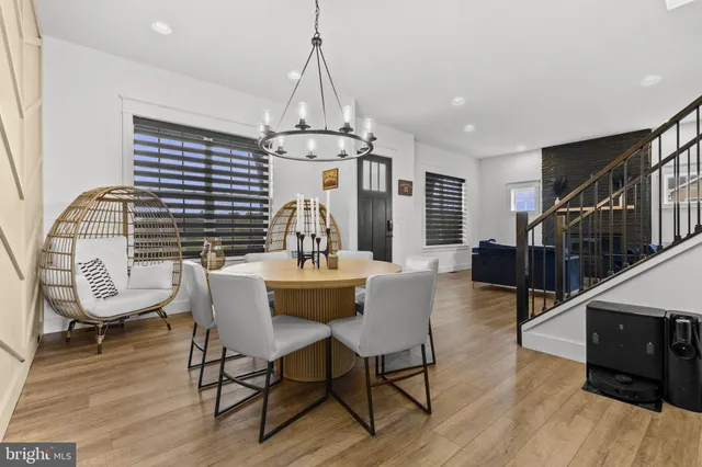 a kitchen with white cabinets stainless steel appliances and wooden floor