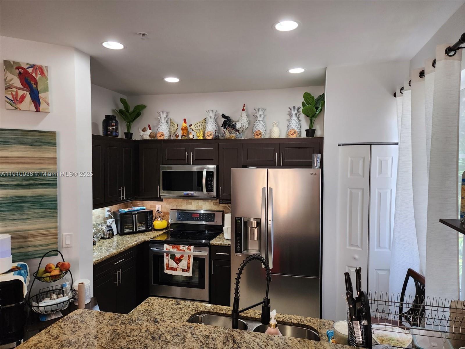 12430 Southwest 50th Street, Unit 147 Miramar, FL 33027 - Photo 3 of 14 a kitchen with stainless steel appliances granite countertop a refrigerator sink and stove