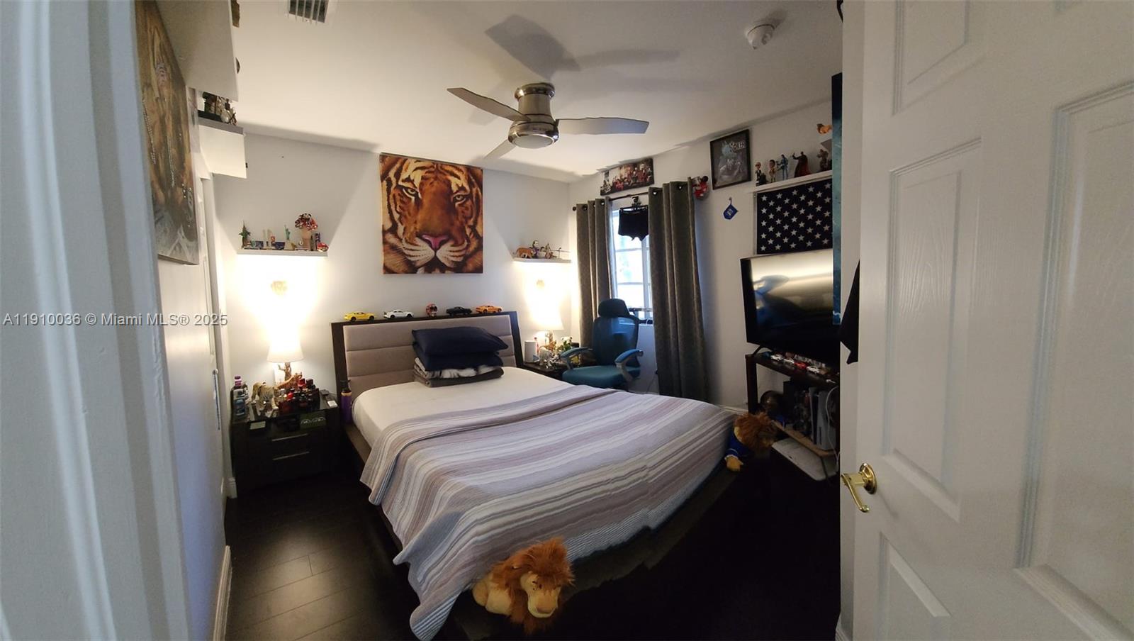 12430 Southwest 50th Street, Unit 147 Miramar, FL 33027 - Photo 10 of 14 a bedroom with a bed and a flat tv screen on dresser