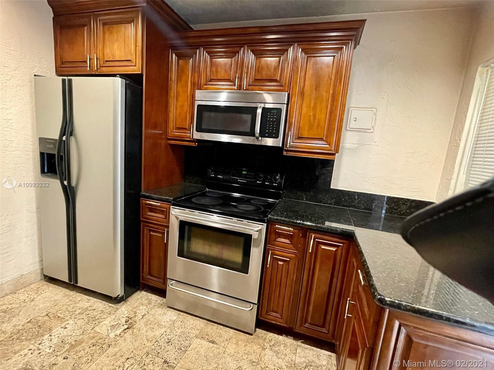2008 Jackson Street, Unit C7 Hollywood, FL 33020 - Photo 4 of 24 a kitchen with stainless steel appliances granite countertop a refrigerator and a sink