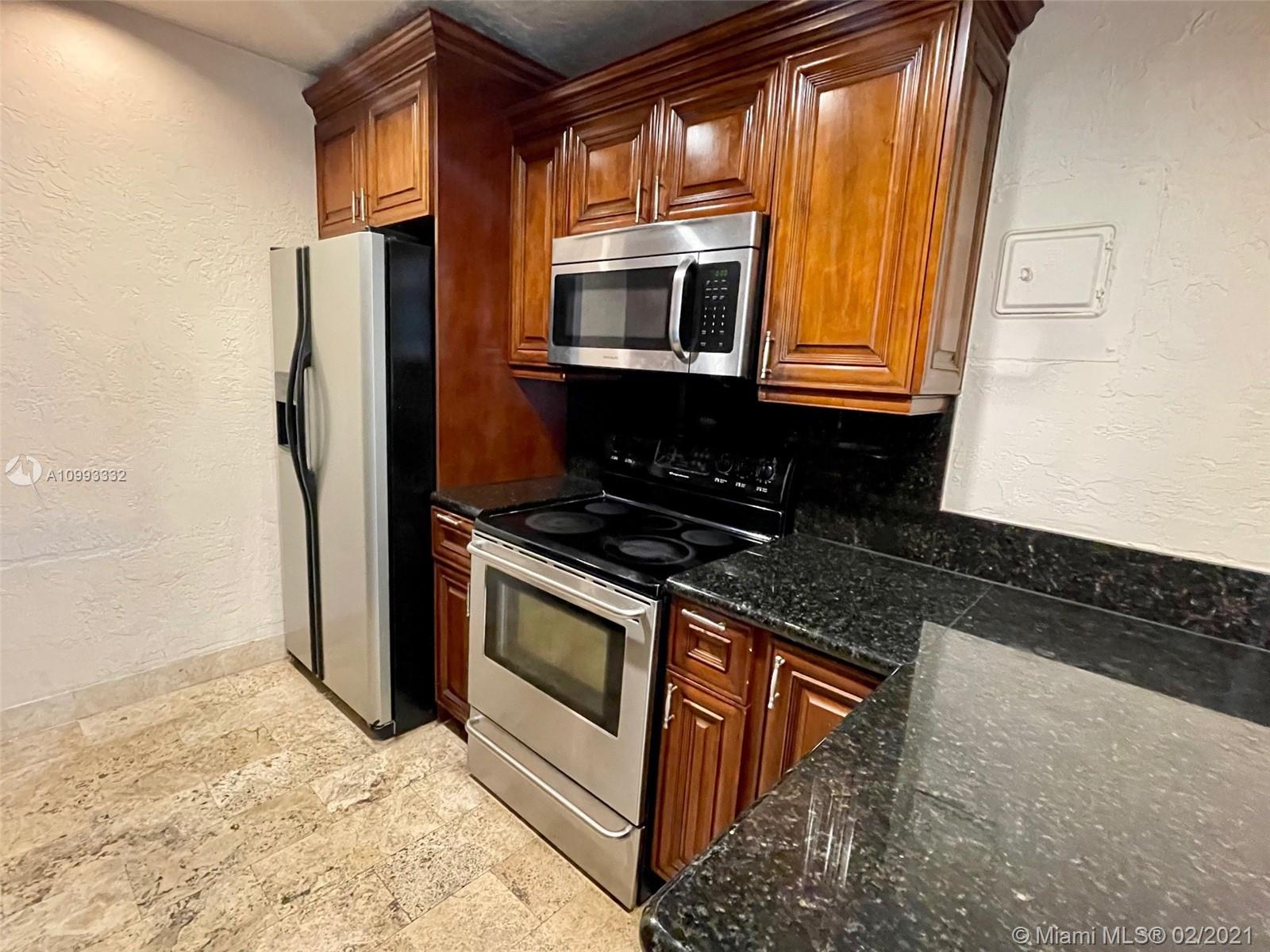 2008 Jackson Street, Unit C7 Hollywood, FL 33020 - Photo 5 of 24 a kitchen with stainless steel appliances granite countertop a refrigerator and a stove