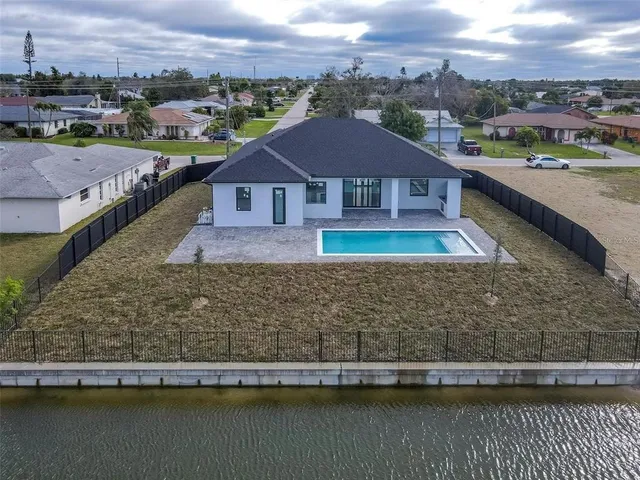 an aerial view of residential houses with outdoor space and parking