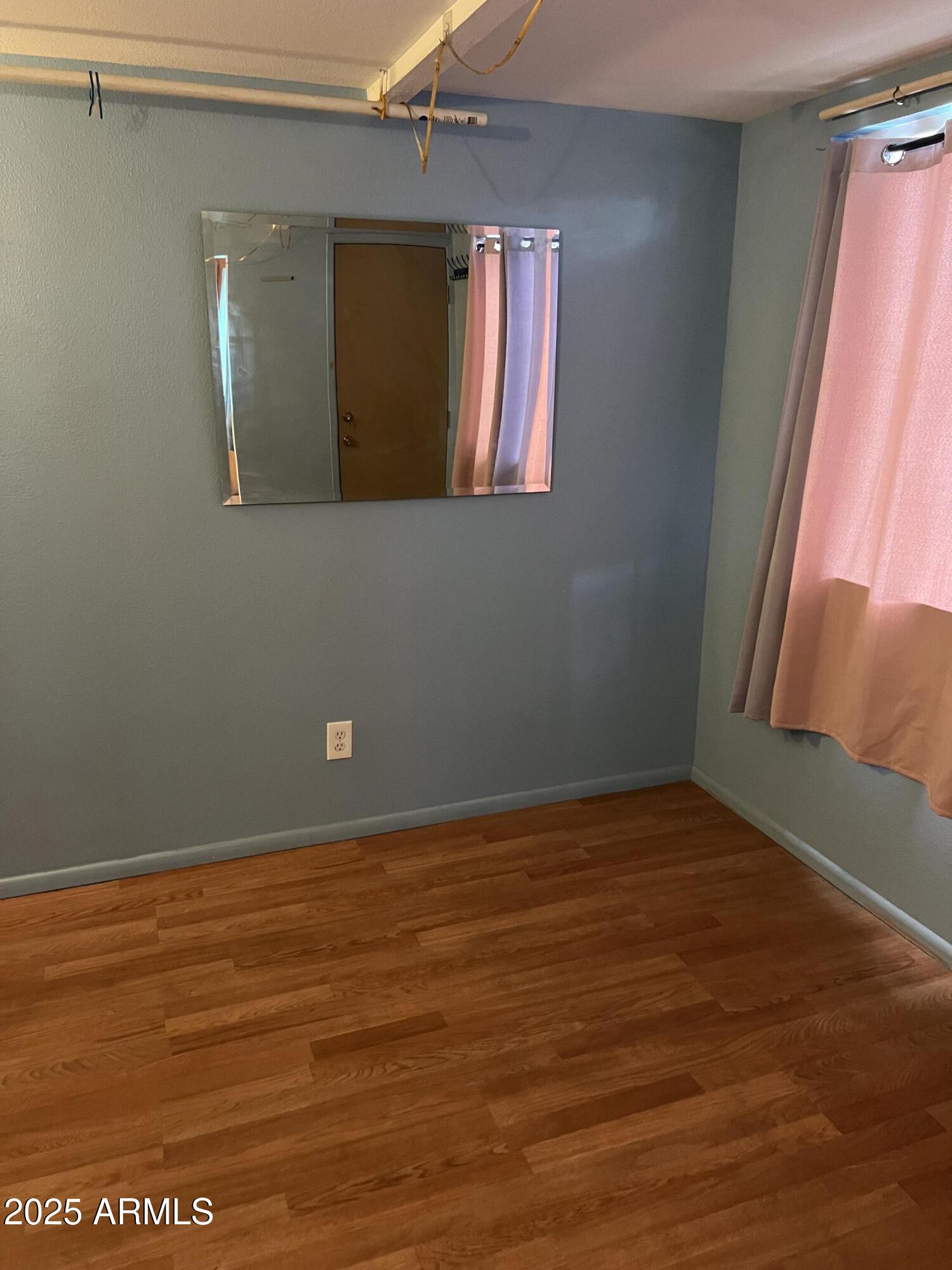 2530 West Berridge Lane, Unit E102 Phoenix, AZ 85017 - Photo 11 of 15 a view of a livingroom with wooden floor and a window