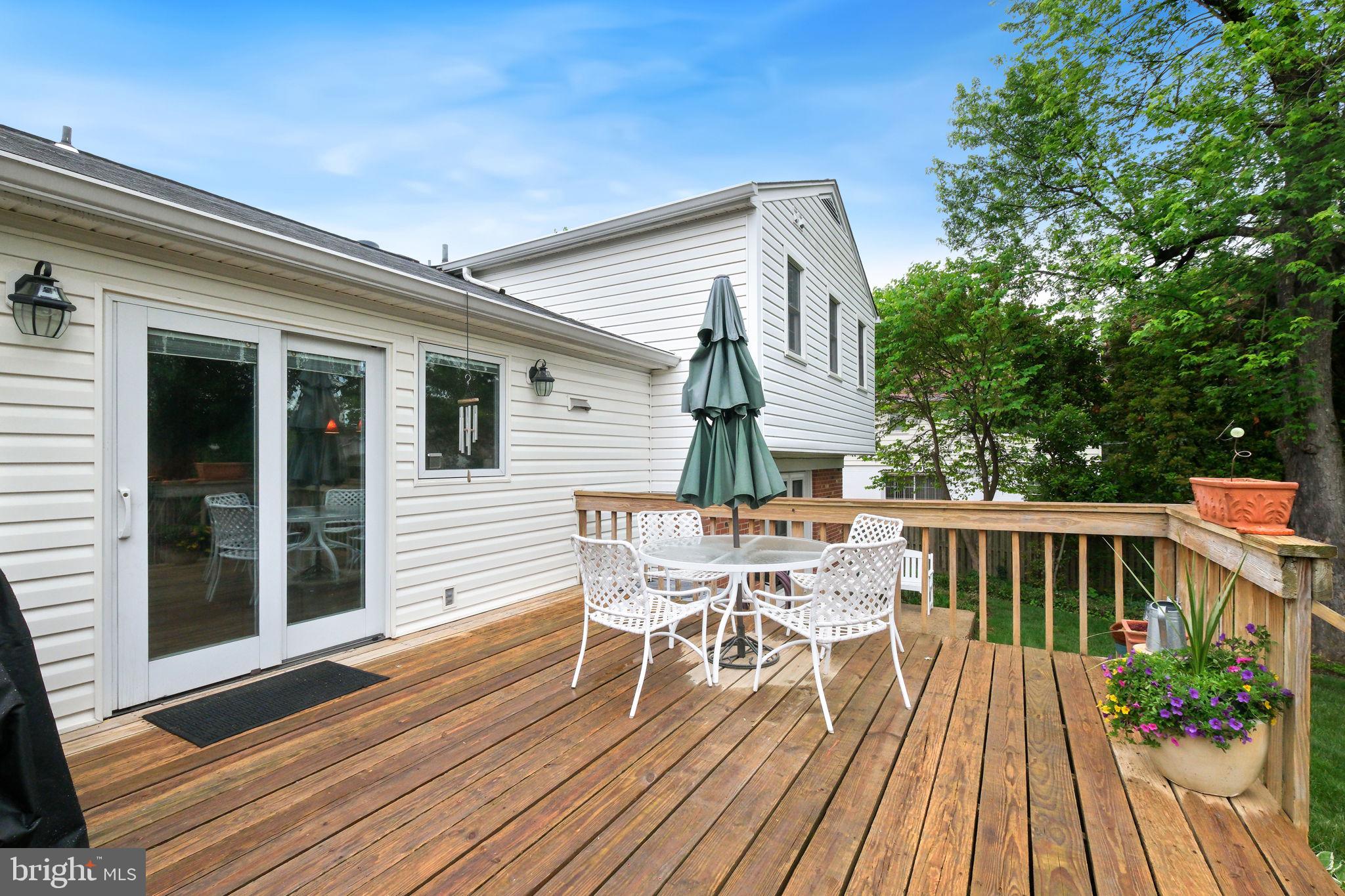 8815 Postoak Road Potomac, MD 20854 - Photo 42 of 45 a view of a roof deck with table and chairs wooden floor and fence