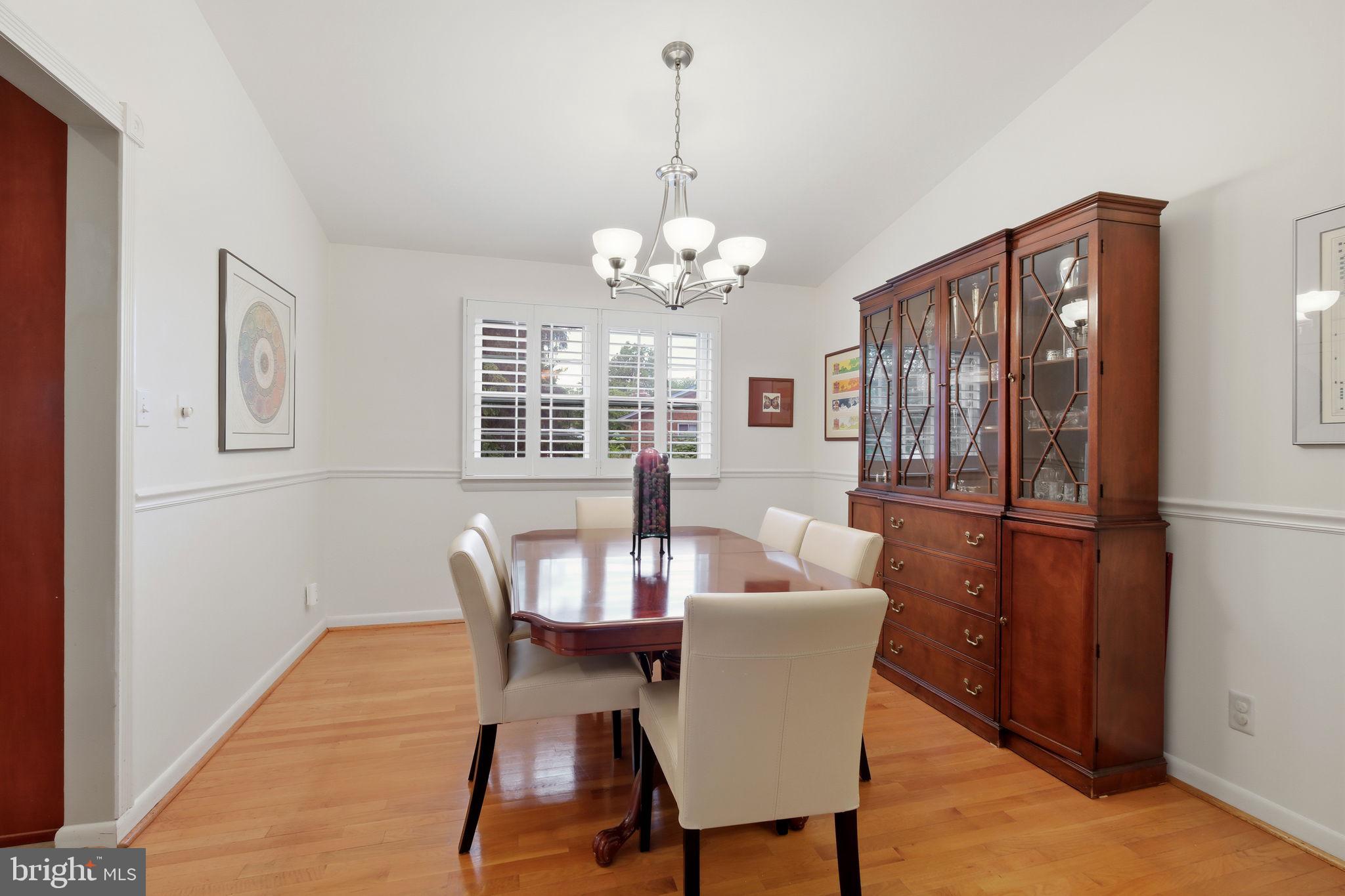 8815 Postoak Road Potomac, MD 20854 - Photo 10 of 45 a dining room with furniture a chandelier and wooden floor