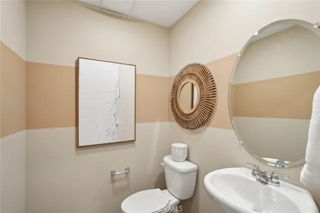 a bathroom with a toilet a sink and a mirror