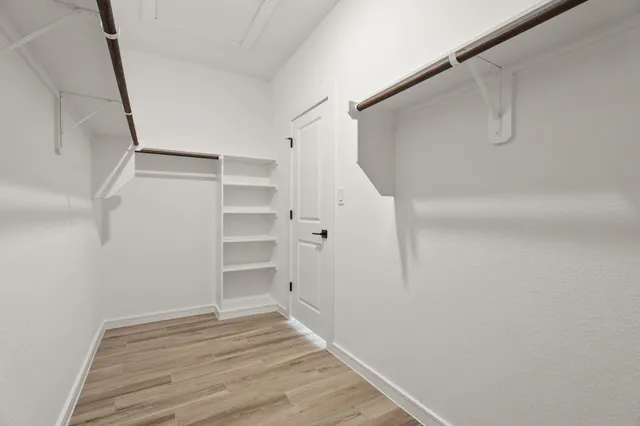 a view of walk in closet with empty racks