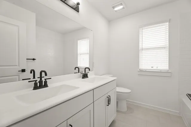 a bathroom with a sink a toilet and a window