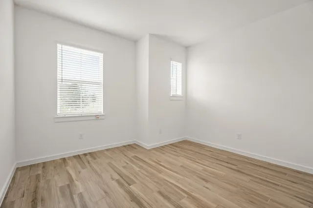 wooden floor in an empty room with a window
