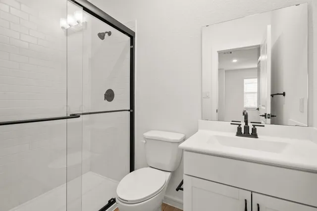 a bathroom with a sink a toilet and shower