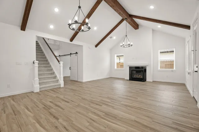 a view of empty room with wooden floor fireplace and stairs