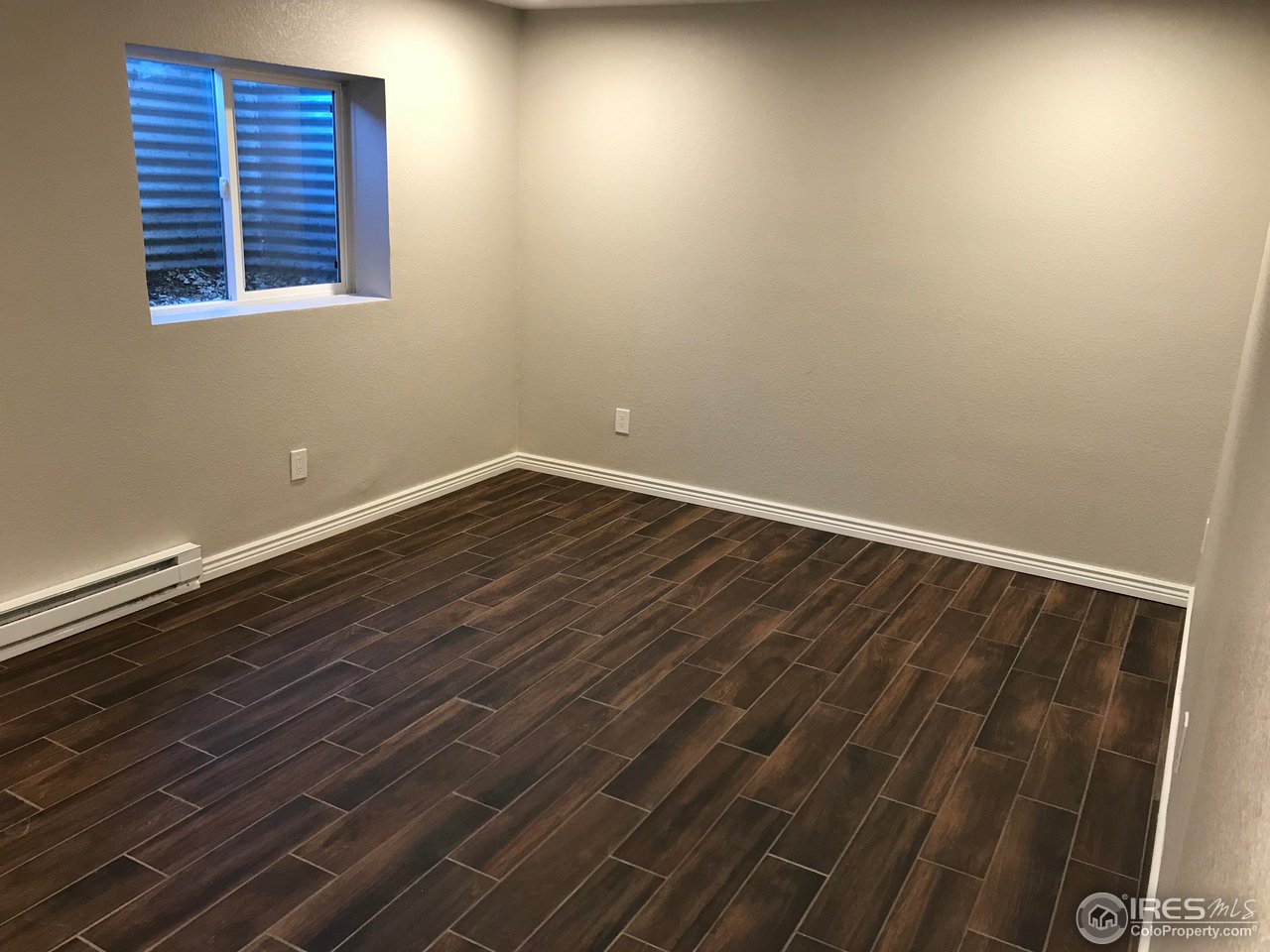 1065 Modred Street Lafayette, CO 80026 - Photo 15 of 23 a view of an empty room with wooden floor and a window