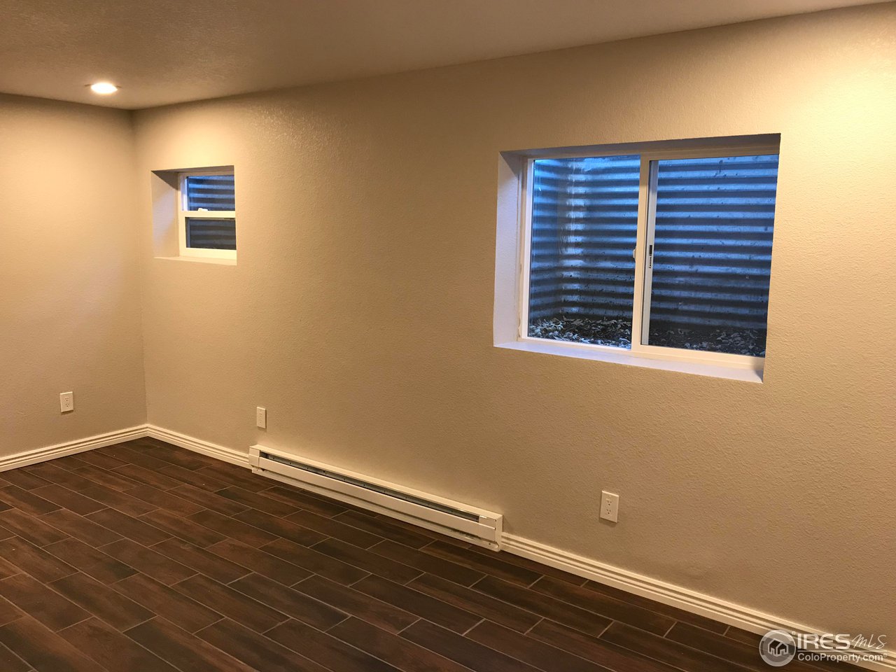1065 Modred Street Lafayette, CO 80026 - Photo 16 of 23 a view of an empty room with wooden floor and a window