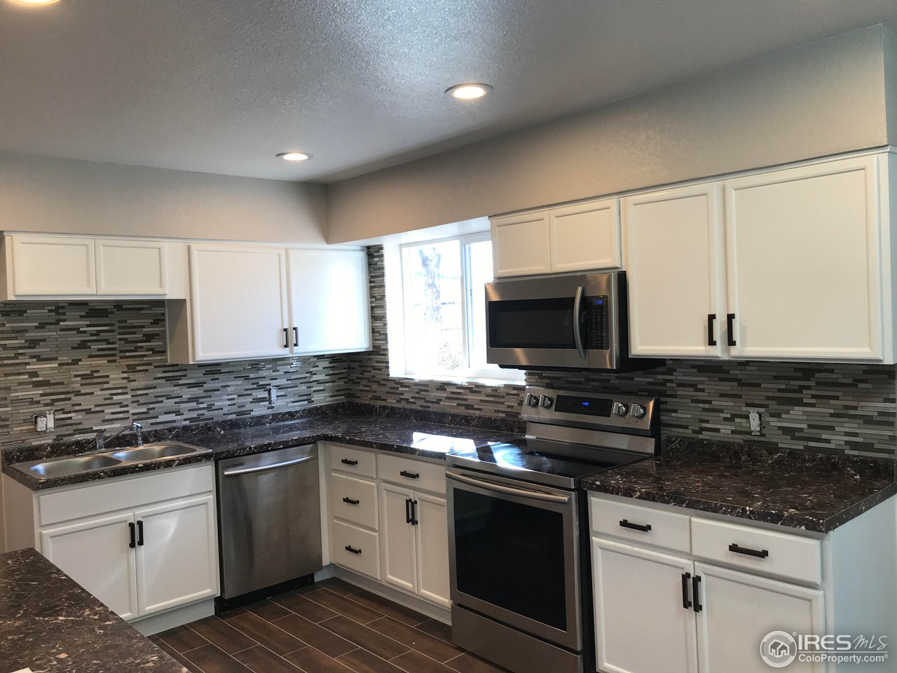 1065 Modred Street Lafayette, CO 80026 - Photo 2 of 23 a kitchen with stainless steel appliances granite countertop a stove a sink and a microwave