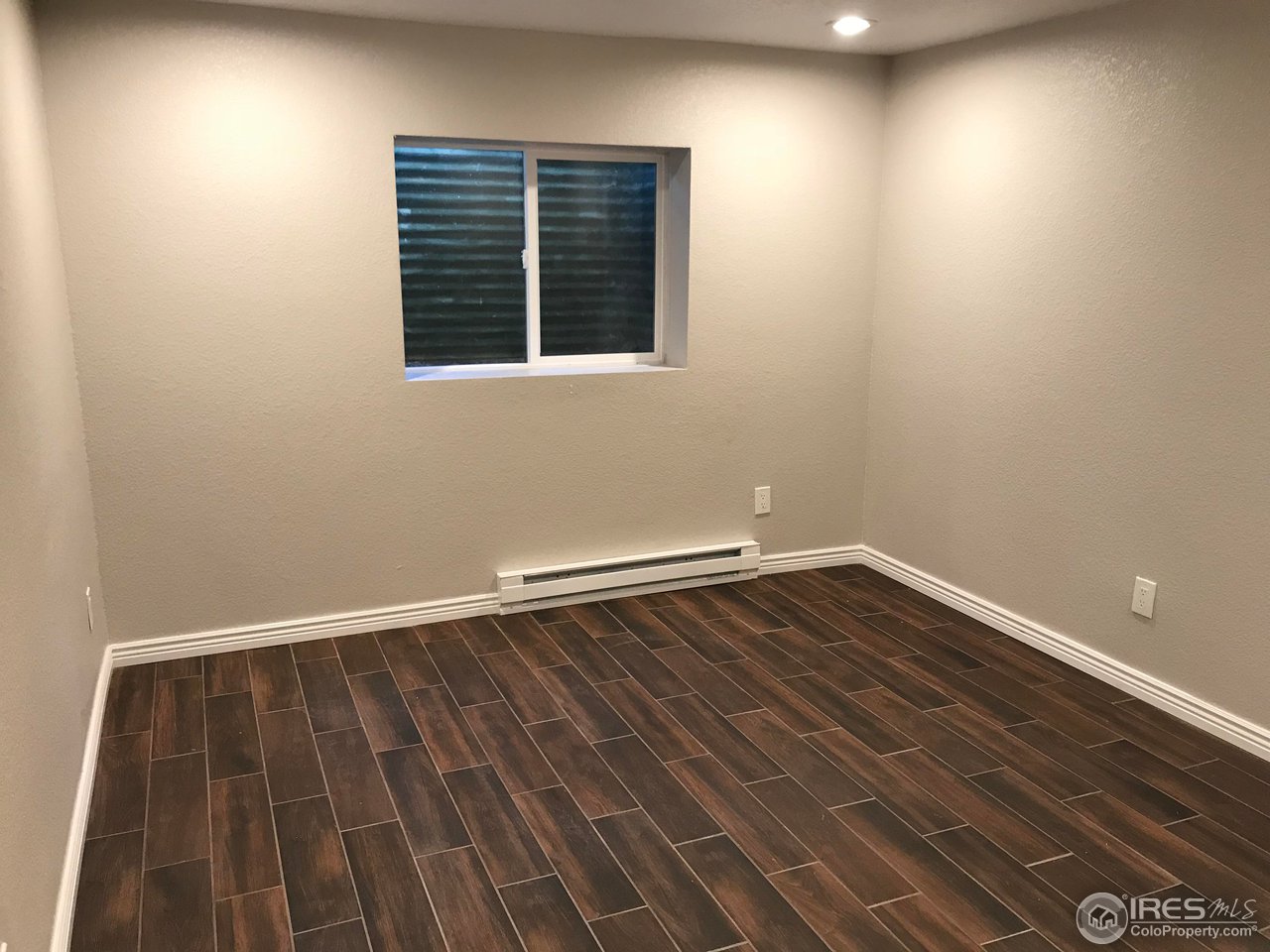 1065 Modred Street Lafayette, CO 80026 - Photo 22 of 23 a view of an empty room with wooden floor and a window