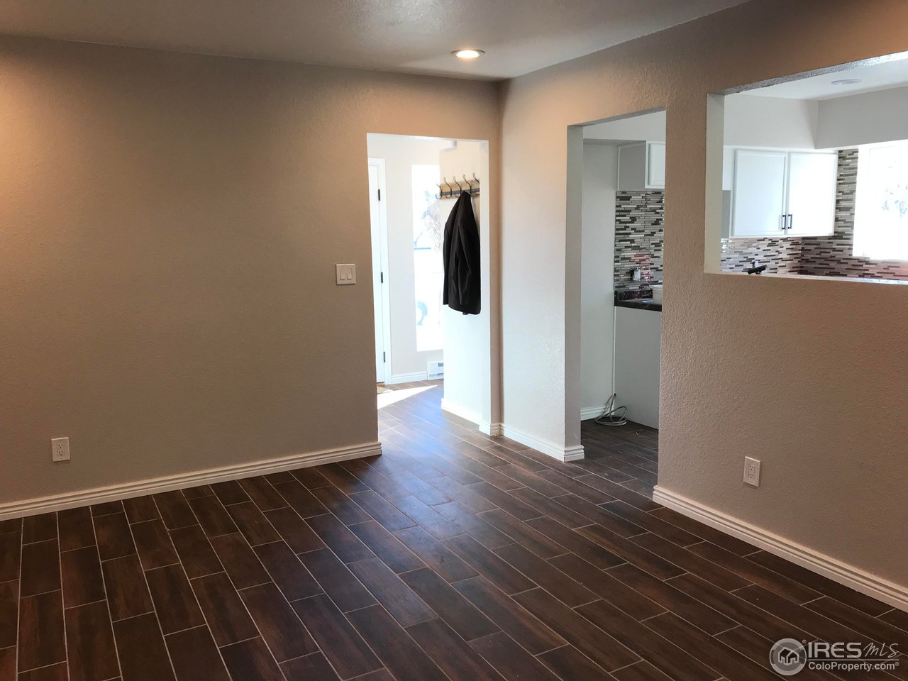 1065 Modred Street Lafayette, CO 80026 - Photo 6 of 23 a view of an empty room with wooden floor and a window