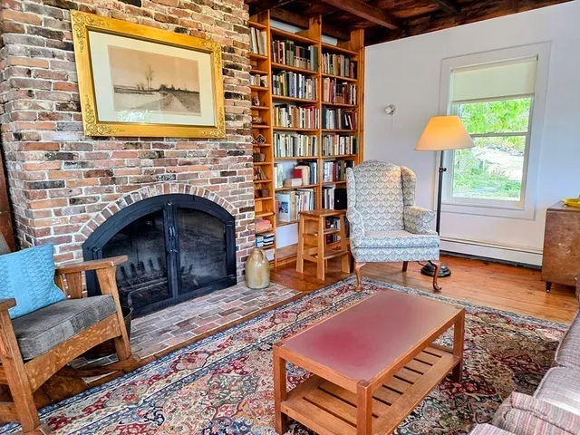 a living room with furniture a rug and a fireplace