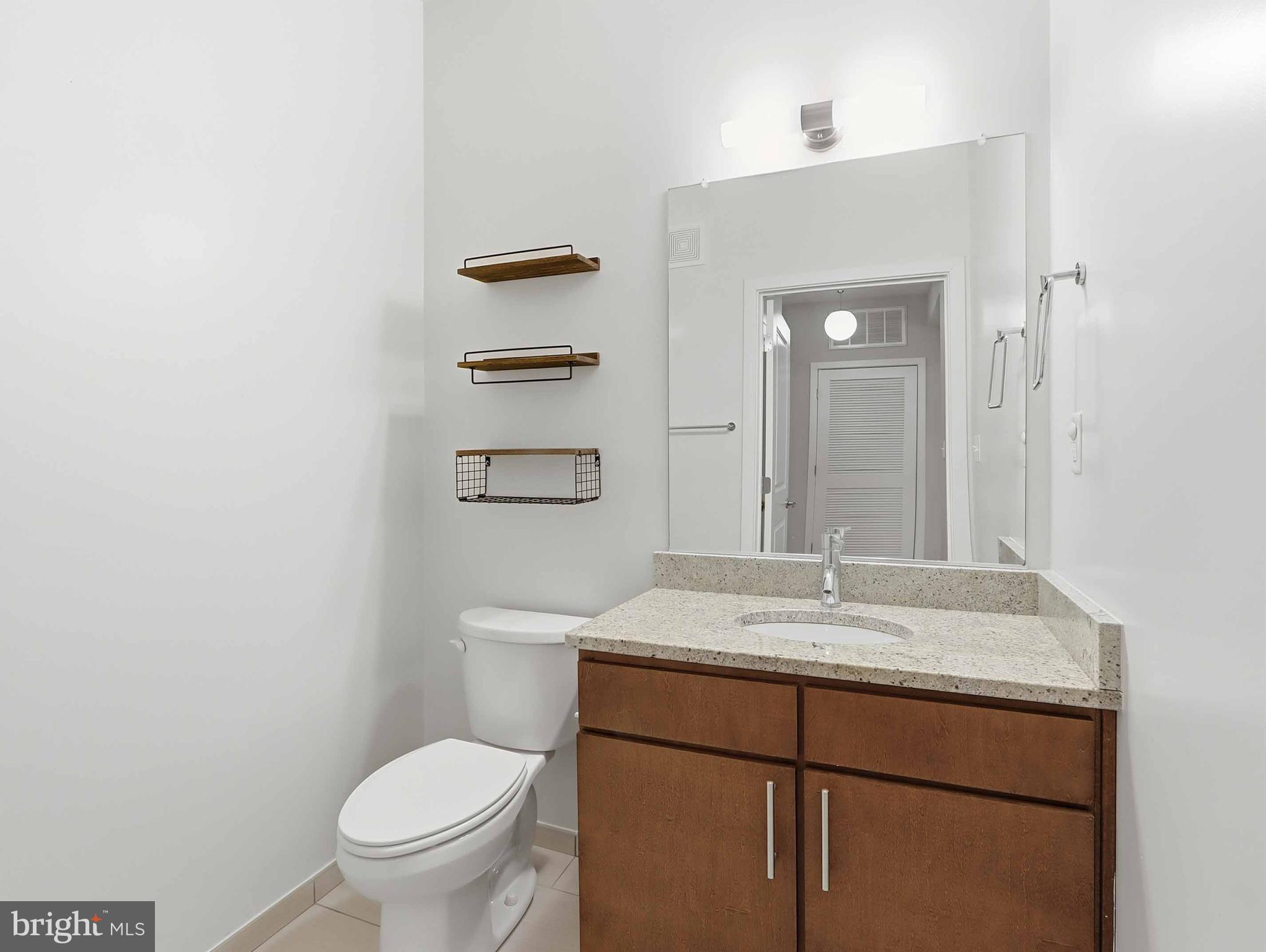 8005 13th Street, Unit 411 Silver Spring, MD 20910 - Photo 18 of 33 a bathroom with a sink toilet and mirror