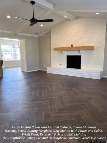 a view of empty room with wooden floor and window