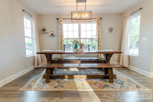 a living room with a table chairs and a window