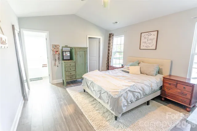 a spacious bedroom with a bed and a refrigerator