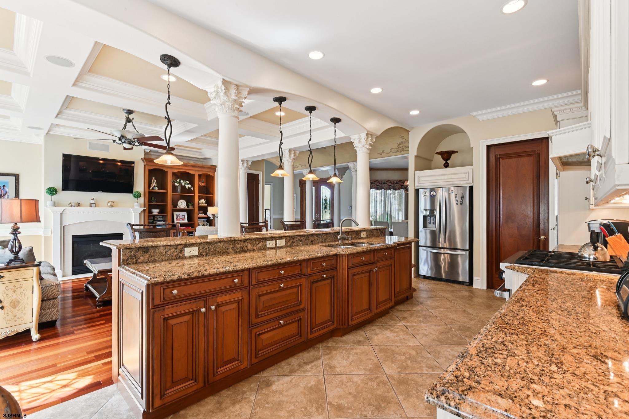 301 Wesley Road Ocean City, NJ 08226 - Photo 9 of 44 a large kitchen with stainless steel appliances granite countertop a large stove top oven a sink dishwasher and a fireplace with wooden floor