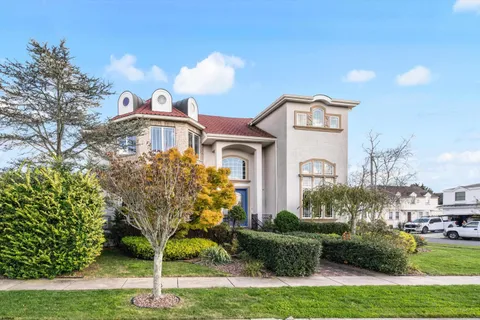 a front view of a house with a yard and potted plants