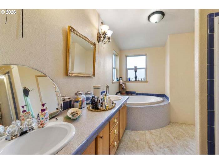514 Eakin Road Azalea, OR 97410 - Photo 11 of 41 a bathroom with a double vanity sink a mirror and a bathtub