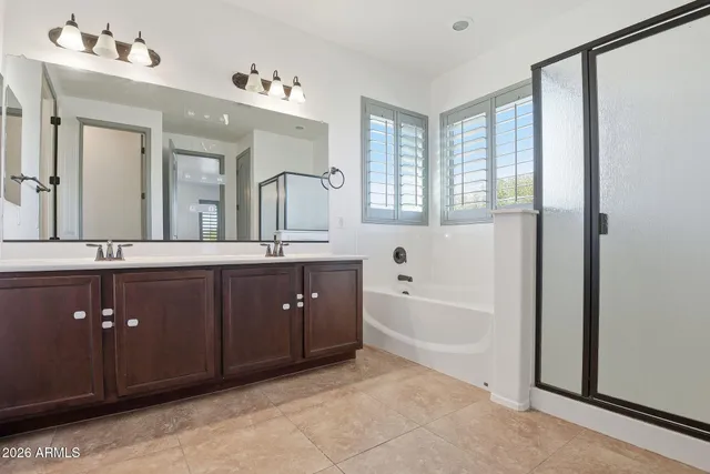 a spacious bathroom with a tub double sink and mirror
