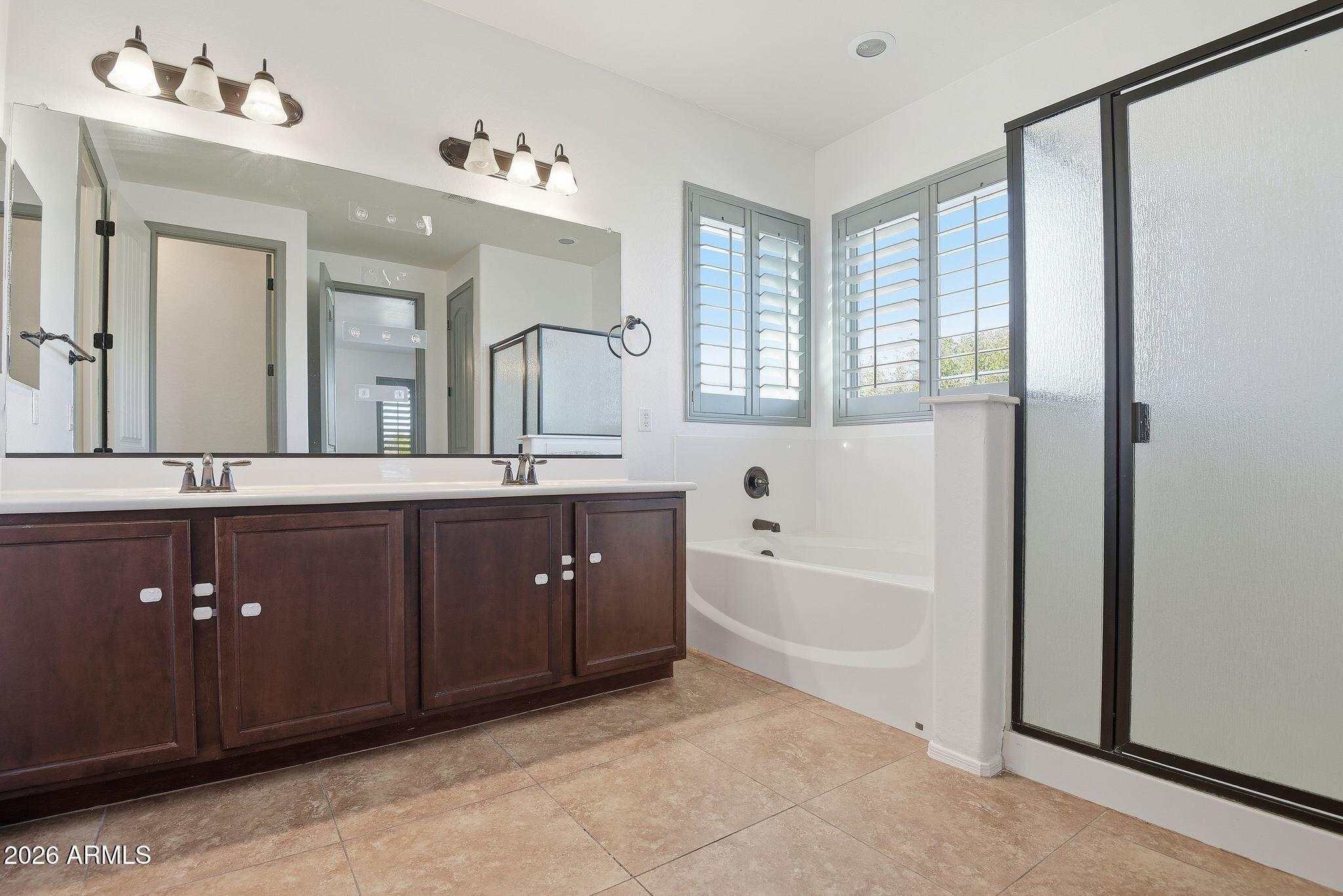 3484 East Mesquite Street Gilbert, AZ 85296 - Photo 12 of 16 a spacious bathroom with a tub double sink and mirror