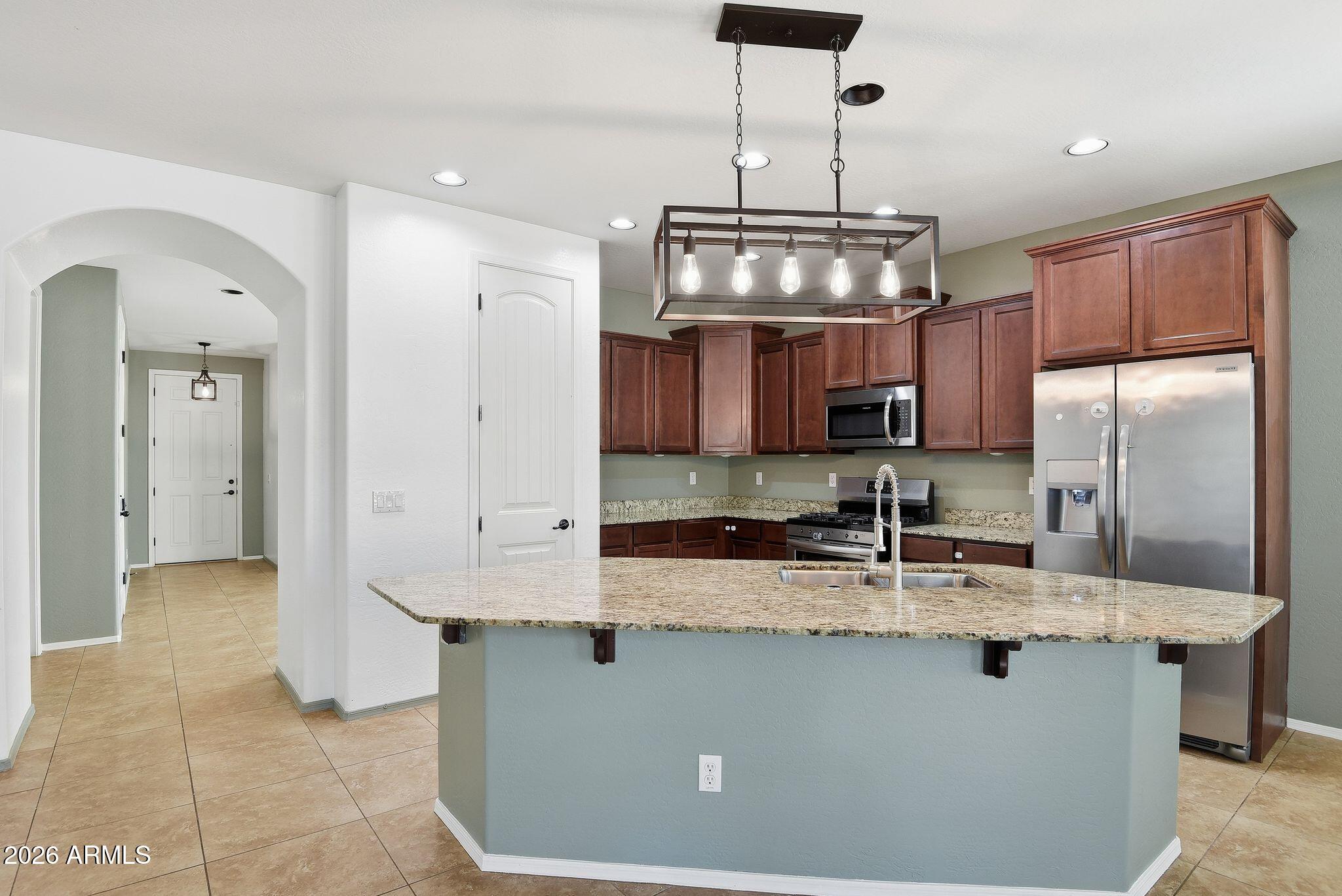 3484 East Mesquite Street Gilbert, AZ 85296 - Photo 6 of 16 a kitchen with stainless steel appliances granite countertop a sink a refrigerator and a granite counter tops