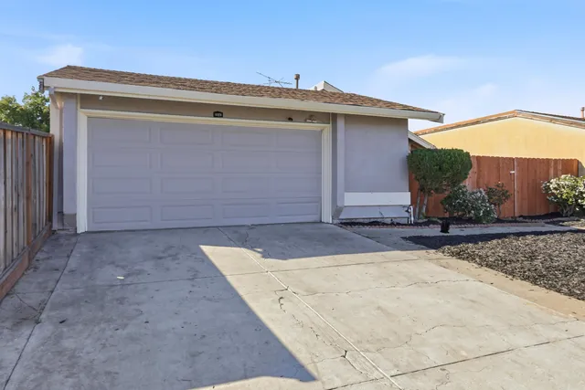 a view of house with garage and plants