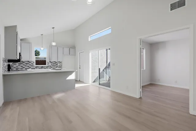 a view of kitchen with stainless steel appliances granite countertop cabinets and wooden floor