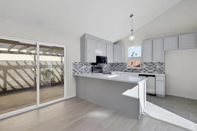 a kitchen with white cabinets and refrigerator