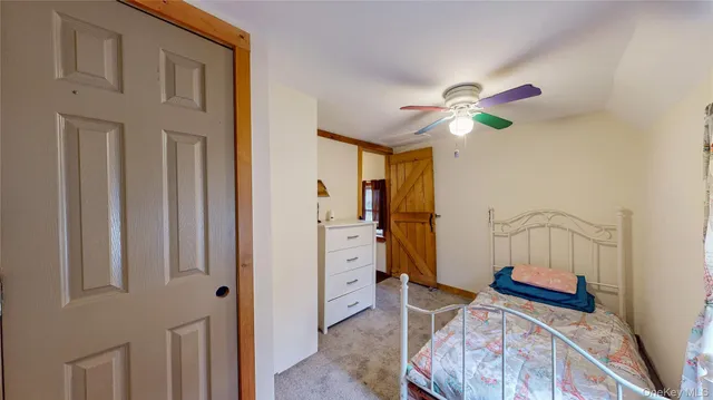 a view of a bedroom with furniture window and a ceiling fan