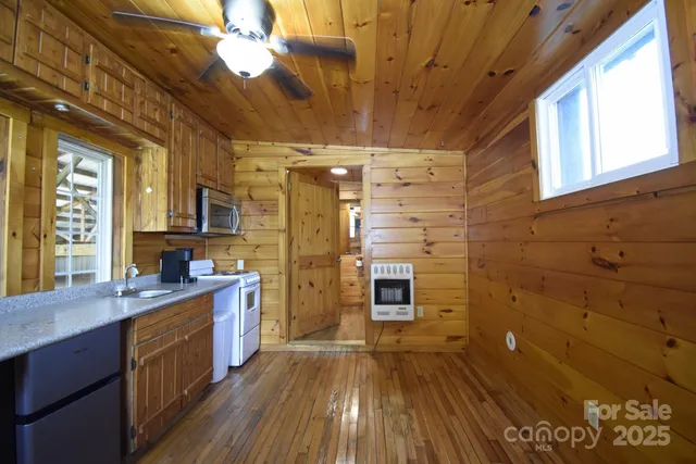 a kitchen with a stove a sink and wooden cabinets