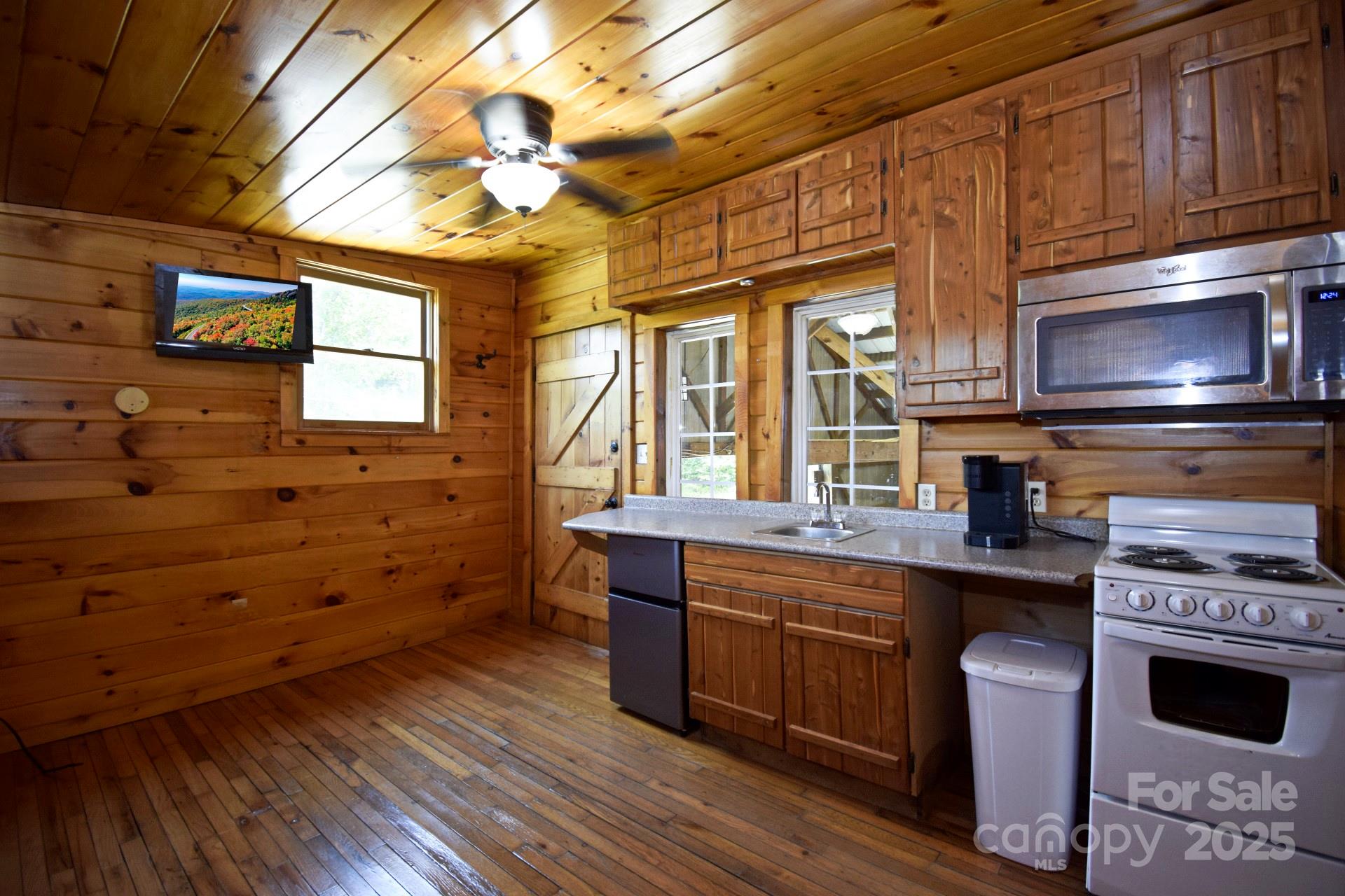 2941 Roby Martin Road Lenoir, NC 28645 - Photo 24 of 47 a kitchen with a stove a sink and wooden cabinets