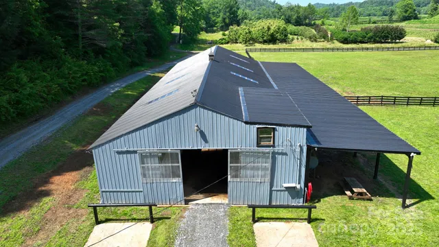 a aerial view of a house with table and chairs a barbeque and wooden fence