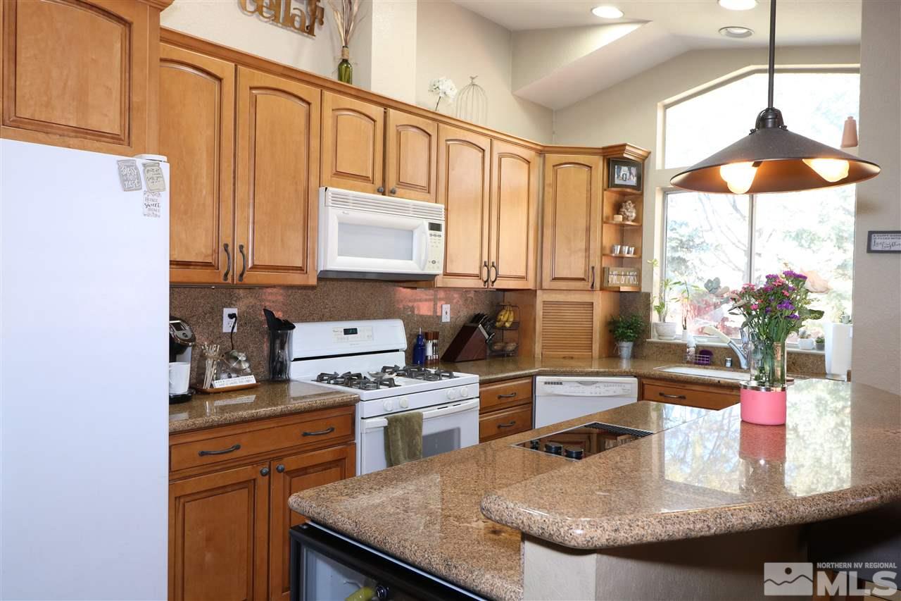 7658 Devonshire Lane Reno, NV 89511 - Photo 4 of 16 a kitchen with stainless steel appliances granite countertop a sink a stove and a refrigerator